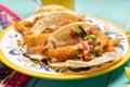 Mexican breaded fish tacos also called ensenada on turquoise background Royalty Free Stock Photo