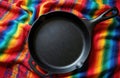 Traditional Mexican comal griddle on colorful fabric. Empty black cast iron cookware. Flat lay composition from above shows Royalty Free Stock Photo