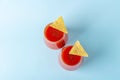 Traditional Mexican cuisine: Nachos, corn tortilla chips with spicy sauce and alcoholic drink Michelada. Two glass of Cocktail Royalty Free Stock Photo