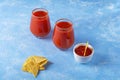 Traditional Mexican cuisine: Nachos, corn tortilla chips with spicy sauce and alcoholic drink Michelada. Two glass of Cocktail Royalty Free Stock Photo