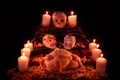 Mexican day of the dead altar with bread and sugar skulls on dark background Royalty Free Stock Photo