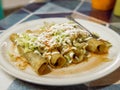 Traditional mexican food taquitos on a plate on a table in Mexico