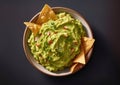 Traditional mexican guacamole avocado dip with nachos on black background.Top view.Macro.AI Generative