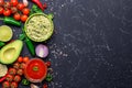 Traditional Mexican Latin American Salsa sauce and Guacamole and ingredients on black stone table. Top view copy space Royalty Free Stock Photo