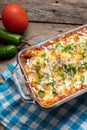 Mexican red baked enchiladas with melted cheese and sour cream on wooden background Royalty Free Stock Photo