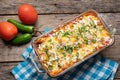 Mexican red baked enchiladas with melted cheese and sour cream on wooden background Royalty Free Stock Photo