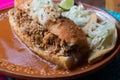 Mexican sandwich with red sauce called `torta ahogada`