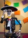 Traditional mexican skeleton sculpture with Mariachi outfit and Sombrero in market alley celebrating Dios de los Muertos