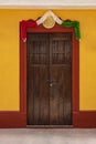 Traditional mexican wooden door with mexican national flag girland Royalty Free Stock Photo