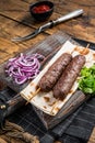 Traditional middle east kefta, kofta kebab from ground beef and lamb meat grilled on skewers served with flatbread and onion.