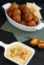 Traditional Middle Eastern food, Falafel (tamiya) with hummus and pickles on black wooden background and green table cloth.