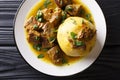 Traditional Mofongo with plantains, garlic and chicharron served with meat and broth close-up on a plate. horizontal top view