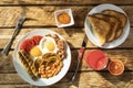 Traditional morning English breakfast - scrambled eggs, white beans, tomatoes, mushrooms, sausages and apricot jam with classic