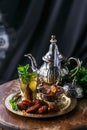 Traditional moroccan mint tea with copper teapot, dates and sugar