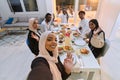 A traditional Muslim family captures the joy of their shared iftar meal during the sacred month of Ramadan through a