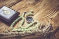 Traditional muslim prayer set bundle. Praying carpet, rosary beads, little version of the Holy Quran and qibla compass on wooden