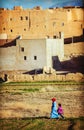 Traditional muslin lady mother and daughter walk in old traditional Morocco Arab field and village.