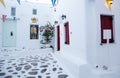 traditional narrow street in Mykonos with blue doors and white walls