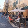 Malta, Marsaxlokk, August 2019. Tourists eat ice cream in a street cafe.