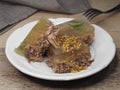 Traditional natural aspic meat with grain dijon mustard in a white plate, fork, napkin on the table, closeup