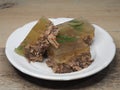 Traditional, natural aspic meat in a white plate on the table, closeup. Recipe for a simple seasonal dish jellied meat