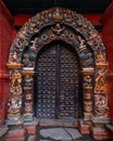 Traditional Nepali door of a temple. The door is deocrated with sculptures of Hindu Gods and creatures