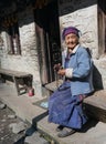 Traditional Nepali Village life. Old woman resting at the front of her house