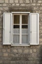 Traditional new white window shutters as blinds on old stone home Royalty Free Stock Photo