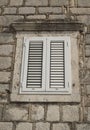 Traditional new white window shutters as blinds on old stone home Royalty Free Stock Photo