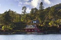 Traditional Norwegian house surrounded by trees and near the sea Royalty Free Stock Photo