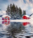 Traditional Norwegian red wooden houses reflected in the calm waters of Kongsjordpollen fjord Royalty Free Stock Photo