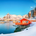 Traditional Norwegian red wooden houses rorbuer on the shore of Reinefjorden near Hamnoy village