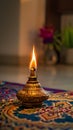 A traditional oil lamp with a flame, placed on a colorful patterned surface Royalty Free Stock Photo