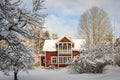 Traditional old big red wooden house in winter countryside. Beautiful cottage or villa with big windows, glazed terrace and balcon