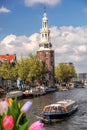 Traditional old buildings and boat on canal against colorful tulips in Amsterdam, Netherlands Royalty Free Stock Photo