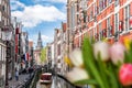 Traditional old buildings and boat on canal against colorful tulips in Amsterdam, Netherlands Royalty Free Stock Photo