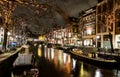 Traditional old buildings and boats at night in Amsterdam Royalty Free Stock Photo