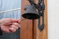 Traditional old door metal bell for ring on wooden door. Royalty Free Stock Photo