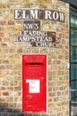 Traditional old English red postbox mounted in a brink wall