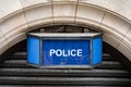 Traditional old fashioned retro blue police sign above arched stone town station door. Royalty Free Stock Photo