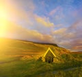 A traditional old house with a roof overgrown with grass and a tent on the beach. Iceland Royalty Free Stock Photo