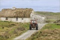 Traditional old irish house with a male on a tractor Royalty Free Stock Photo