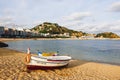 Traditional old wooden fishing boat on the rocky beach. Travel concept. Costa Brava, Spain. Fishing boat rest on golden sand beach Royalty Free Stock Photo