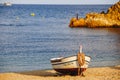 Traditional old wooden fishing boat on the rocky beach. Travel concept. Costa Brava, Spain. Fishing boat rest on golden sand beach Royalty Free Stock Photo