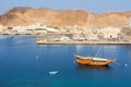 Traditional Omani boat Dhow in the port of Mutrah in Muscat and in the background the fish market and the Corniche Royalty Free Stock Photo