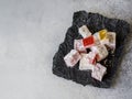 Traditional oriental dessert Turkish Delight on black paper on grey background. Copy space Royalty Free Stock Photo