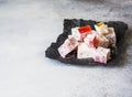 Traditional oriental dessert Turkish Delight on black paper on grey background. Copy space Royalty Free Stock Photo