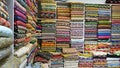 Traditional oriental multicolored clothes stacked in store. Dubai market. Global village pavilion. Selective focus.  Small depth Royalty Free Stock Photo