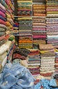 Traditional oriental multicolored clothes stacked in store. Dubai market. Global village pavilion. Selective focus.  Small depth Royalty Free Stock Photo