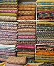 Traditional oriental multicolored clothes stacked in store. Dubai market. Global village pavilion. Selective focus. Small depth